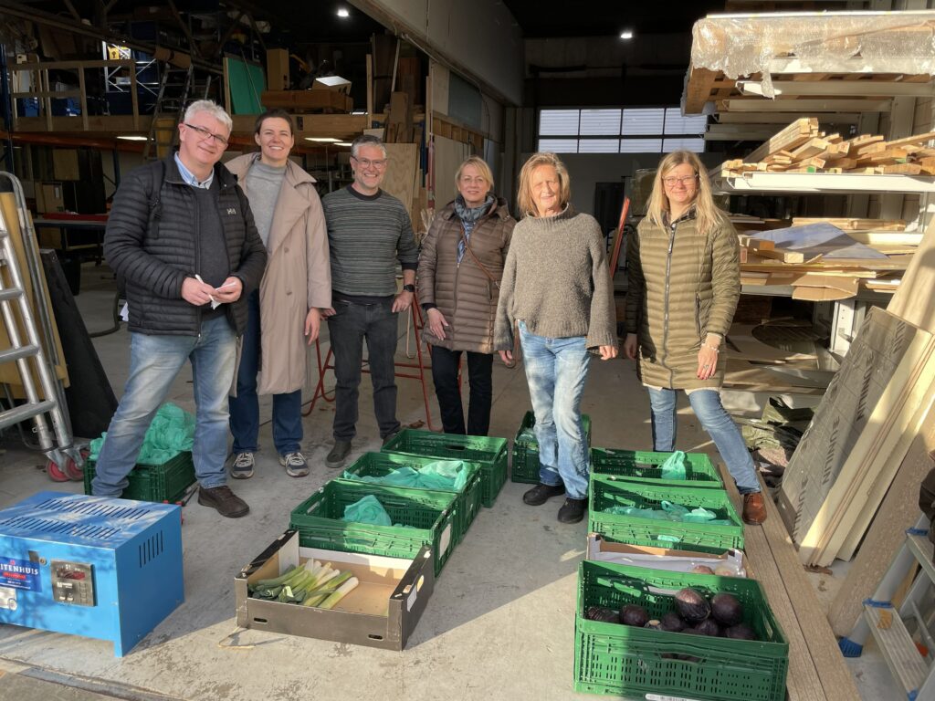 People gathered in front of fruit and vegetable crates