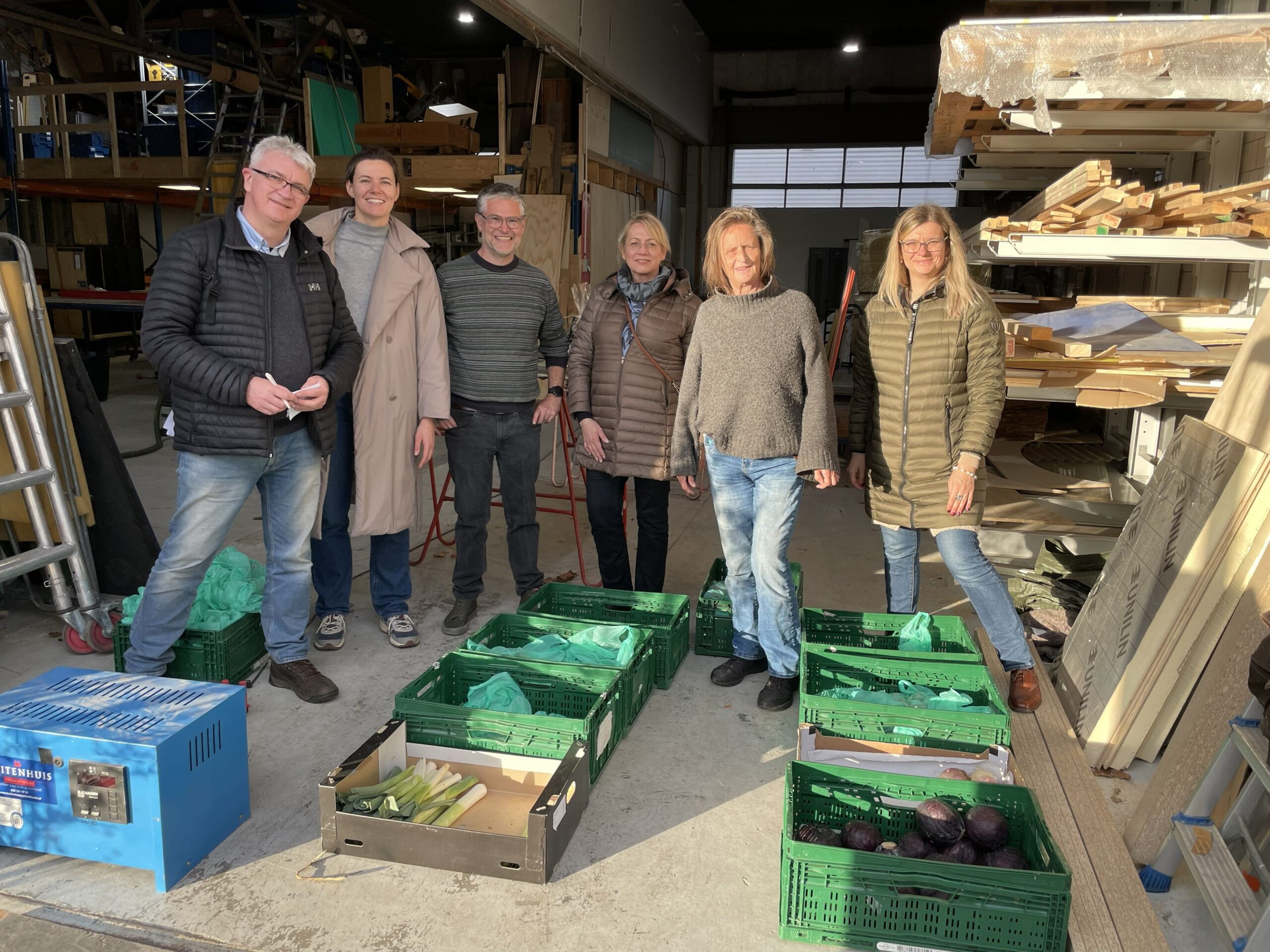 People gathered in front of fruit and vegetable crates
